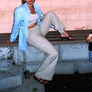 Woman and child sit on steps in a brick archway.