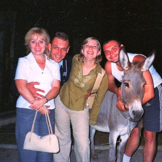 Family posing with a donkey at night.