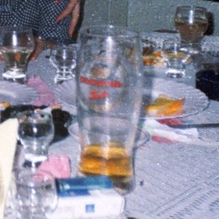 Four women are posing at a table with drinks.
