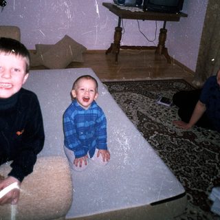 Three young boys playing in a room with vintage decor.