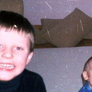 Three young boys playing in a room with vintage decor.