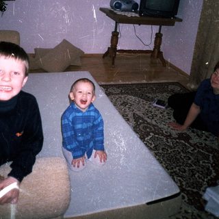Three young boys playing in a room with vintage decor.