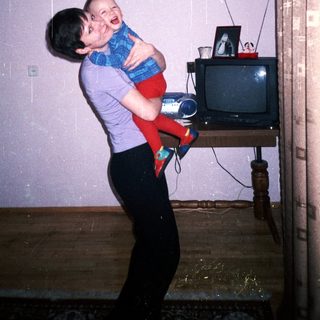 Person playfully lifts a baby in a home interior.