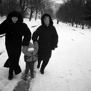 Two adults and a child are walking in the snow.