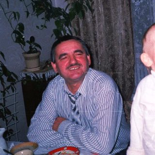 Man and child smiling, posing for a vintage photograph.