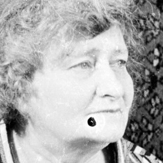 Black and white portrait of an elderly woman seated.