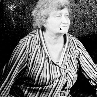 Black and white portrait of an elderly woman seated.