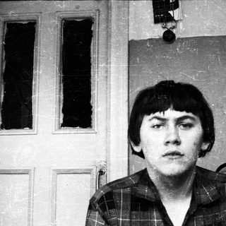 Black and white portrait of a young man with a serious expression.