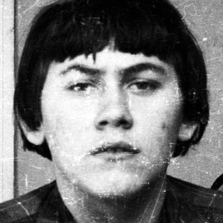 Black and white portrait of a young man with a serious expression.