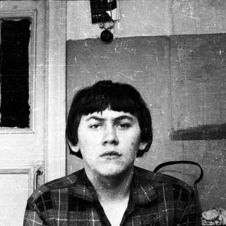 Black and white portrait of a young man with a serious expression.