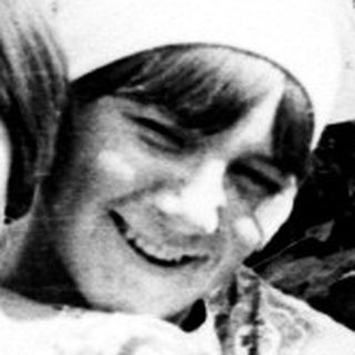 Two children sitting outside, posing for a black and white photo.