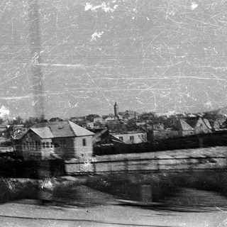 Vintage black and white view of a town with buildings.