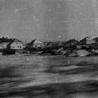 Coastal flooding damages homes in a vintage black and white photo.