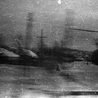 Monochrome landscape with trees, snow, and visible film grain.