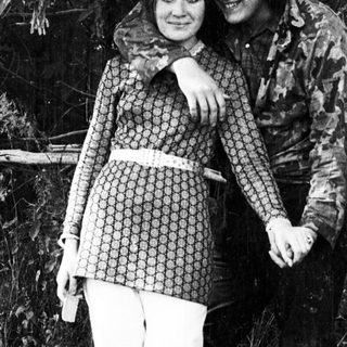 Couple poses outdoors, embracing, in a vintage style.