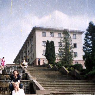 Man, woman, and dog pose on stone steps.