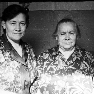 Here's a brief summary of the image: Three women pose for a black and white portrait.