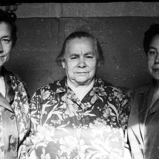 Here's a brief summary of the image: Three women pose for a black and white portrait.