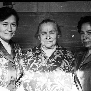 Three women pose for a black and white portrait.