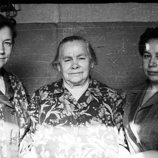 Three women pose for a black and white portrait.