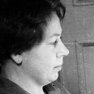Woman reading a newspaper in a vintage, black and white photo.