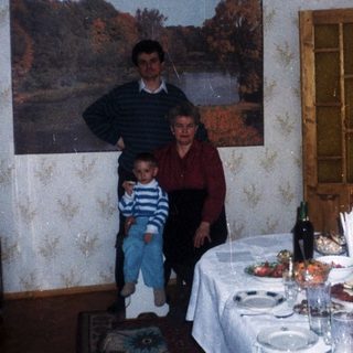 A family stands near a table set for a meal.