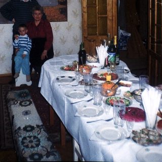 A family stands near a table set for a meal.