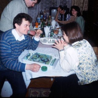 Group gathered around a table with drinks and food.