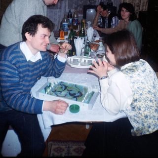 Group gathered around a table with drinks and food.