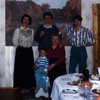 Family portrait in a dining room with a long table.