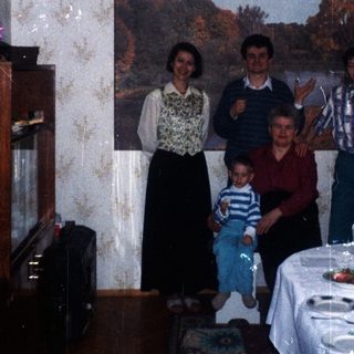 Family portrait in a dining room with a long table.