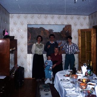 Family portrait in a dining room with a long table.