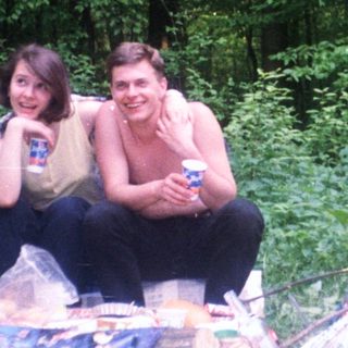 Couple relaxes outdoors with picnic and coconuts.