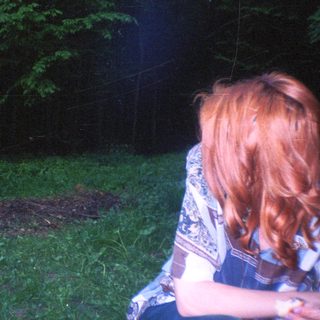 Person stands in grassy area, viewed from behind.