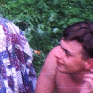 Three people relax outdoors amidst lush greenery and foliage.