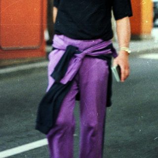 Man stands near a booth, cars visible in the background.