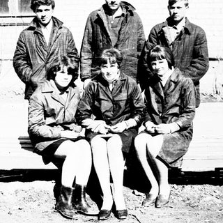 Group of young people posing outdoors near a building.