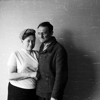 Black and white portrait of a couple standing close together.