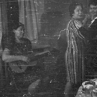 Here's a brief summary of the image: Three people stand near a table with decorative items.