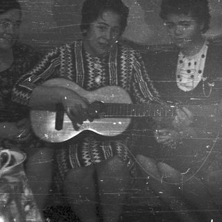 Three people playing music indoors, vintage black and white photo.