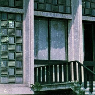 People sit on steps in front of a modern building.