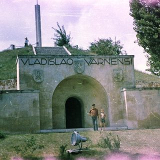 Monument with inscription, two boys, and a loudspeaker.