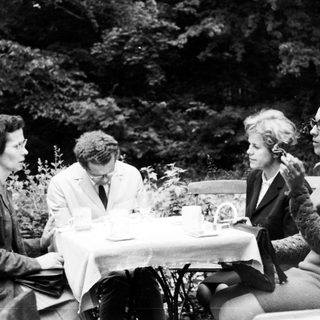 Four people seated at a table outdoors.