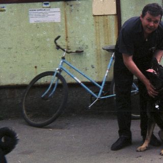Man interacting with a dog in an outdoor setting.