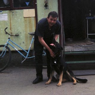 Man interacting with a dog in an outdoor setting.