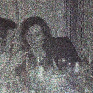 Group seated at a table, dimly lit, appears to be dining.