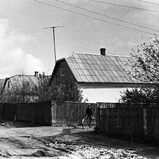 Black and white image of a house with a bicycle.