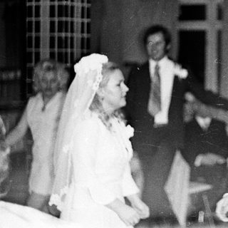 Couple dancing at a wedding reception, black and white photo.