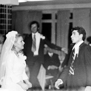 Couple dancing at a wedding reception, black and white photo.