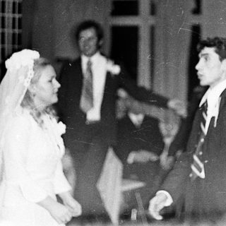 Couple dancing at a wedding reception, black and white photo.